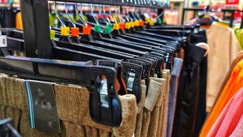 linhas do calças dentro uma roupas loja suspensão ordenadamente em cabides. foto