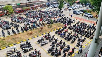 bekasi, Indonésia em dezembro 23 2023. muitos motorizado veículos do vários tipos preencher a Bekasi estação estacionamento muito. foto