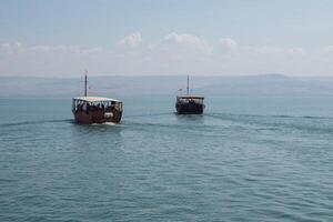 de madeira barcos flutuando em a mar do Galiléia, Israel. ensolarado dia em kinneret foto