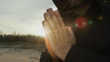 mãos do uma monge Rezar às pôr do sol dentro campo natureza foto
