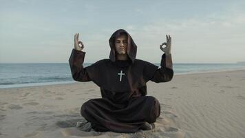 monge faz respiração meditação sentado em a de praia às pôr do sol foto