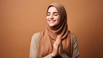 europeu mulher vestindo cachecol é Rezar e sorridente em Castanho fundo foto