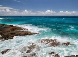 a oceano é azul e branco com pedras e nuvens foto