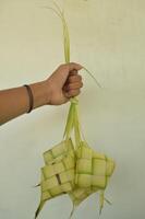 ketupat isolado em branco fundo. uma típica eid al-fitr prato fez a partir de arroz embrulhado dentro uma embrulho fez a partir de tecido jovem coco folhas. típica malaio e indonésio Comida foto