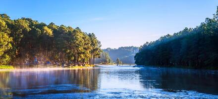 acampamento e viagem bonito natureza panorama Visão do pontada ung lago dentro a névoa às nascer do sol. foto