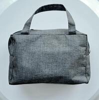 bolsa ou saco tecido com cinzento cor em branco fundo foto