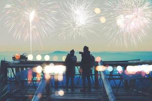 amante mulheres e homens asiáticos. assistir os fogos de artifício. feliz no dia da celebração do dia de ano novo na montanha na Tailândia. foto