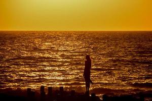 mulher vendo o pôr do sol no porto de agaete foto