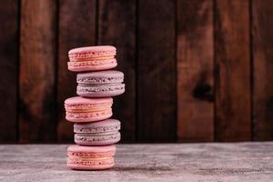 lindos macaroons saborosos cor de rosa em um fundo de concreto foto