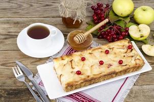 torta de maçã de outono com bagas de viburnum em fundo de madeira foto