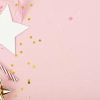 festa feriado fundo com fita, estrelas, velas de aniversário e confetes em fundo rosa. foto de estúdio