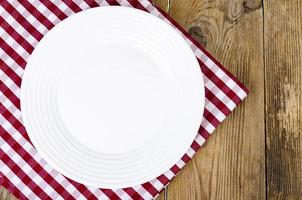 conceito de Natal e ano novo. prato branco, toalha de mesa vermelha. foto de estúdio