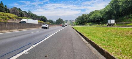 pavimentou estrada com carros passagem de em uma ensolarado dia dentro Campinas foto