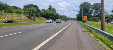 pavimentou estrada com carros passagem de em uma ensolarado dia dentro Campinas foto