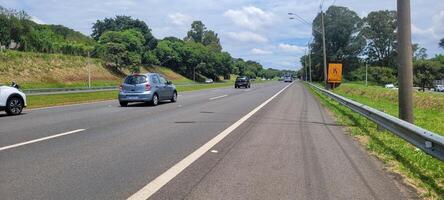 pavimentou estrada com carros passagem de em uma ensolarado dia dentro Campinas foto