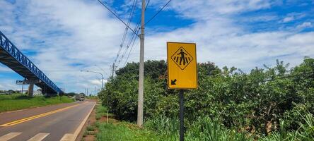 pedestre placa em pavimentou estrada foto