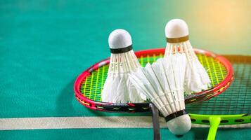 branco badminton petecas e badminton raquetes em verde chão interior badminton quadra suave e seletivo foco em petecas e a raquetes foto