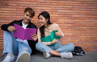 grupo do jovem interracial diverso universidade alunos lendo livro didático e sentado lado de fora uma Sala de aula debaixo uma prédio, noivando dentro uma discussão junto, Faculdade campus, desfrutando campus lazer. foto