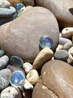 colorida mármores entre suave rio pedras dentro brilhante luz solar, perfeito para natureza e Projeto temas foto