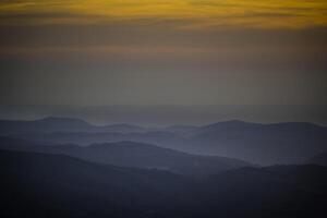 pôr do sol Visão sobre a rolando montanhas e colinas do serra de Monchique foto