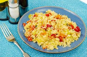 pilaf de cuscuz vegetariano com legumes na placa azul. foto de estúdio