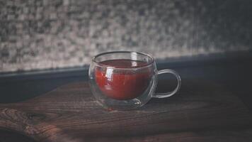 vidro copo com tomate suco em uma de madeira corte borda foto