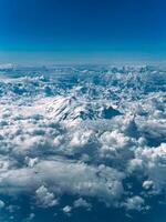 aéreo Visão do íngreme rochoso coberto de neve montanha alcance em lindo ensolarado dia foto