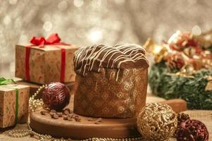 panetone de chocolate na mesa de madeira com enfeites de natal