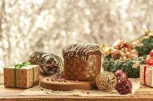 panetone de chocolate na mesa de madeira com enfeites de natal foto