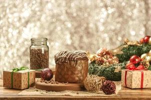 panetone de chocolate na mesa de madeira com enfeites de natal foto