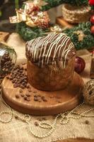 panetone de chocolate na mesa de madeira com enfeites de natal