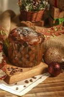 panetone de chocolate na mesa de madeira com enfeites de natal foto