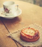 sobremesa e vintage chá copo em a velho de madeira mesa foto