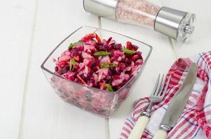 Salada de legumes com beterraba, especiarias, cebola, alho na mesa de madeira foto