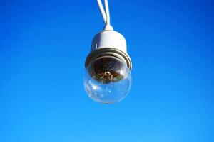 equipado e elétrico com luz lâmpadas é suspensão dentro a vento e luz solar em azul céu foto