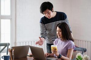 jovem universidade homem Socorro amigo tutorial matemática, física antes exame dentro vivo quarto de conectados classe dentro computador portátil computador. foto