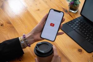 Chiang maio, Tailândia - mar 12, 2021. mulher mãos segurando Smartphone e usando Youtube serviço aplicativo. foto