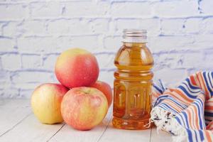 maçãs frescas e garrafa de suco na mesa foto