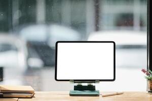 brincar imagem do uma Preto digital tábua com branco em branco tela em de madeira escrivaninha. foto