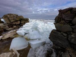 cristalino gelo folhas fratura e flutuador em da rússia lago ladoga, capturando a rígido beleza do primavera descongelamento debaixo uma nublado céu. foto