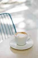 copo do cappuccino em uma mesa dentro uma rua cafeteria. foto