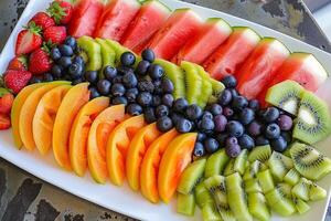 uma colorida fruta prato com melancia, kiwi, morangos e amoras. foto