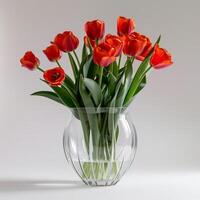 translúcido acrílico vaso preenchidas com fogosa vermelho tulipas. foto
