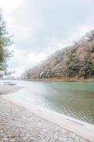 lindo panorama do uma rio com uma barco em isto e uma montanha dentro a fundo. foto