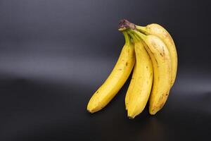 ramo do bananas com Castanho pontos em uma cinzento gradiente fundo. foto
