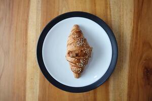 uma prato do defumado carne croissants em a mesa fundo foto