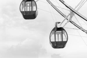 fechar acima Preto e branco ferris roda em diversão parque com nuvem fundo foto