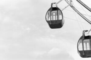 fechar acima Preto e branco ferris roda em diversão parque com nuvem fundo foto