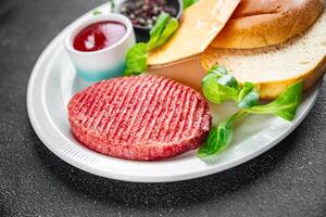 hamburguer conjunto cru costeleta, pão, queijo, tomate molho, verduras fresco cozinhando Aperitivo refeição Comida lanche em a mesa cópia de espaço Comida fundo rústico foto