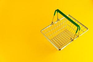 cesta de compras em um fundo amarelo brilhante com um lugar vazio para uma inscrição. foto